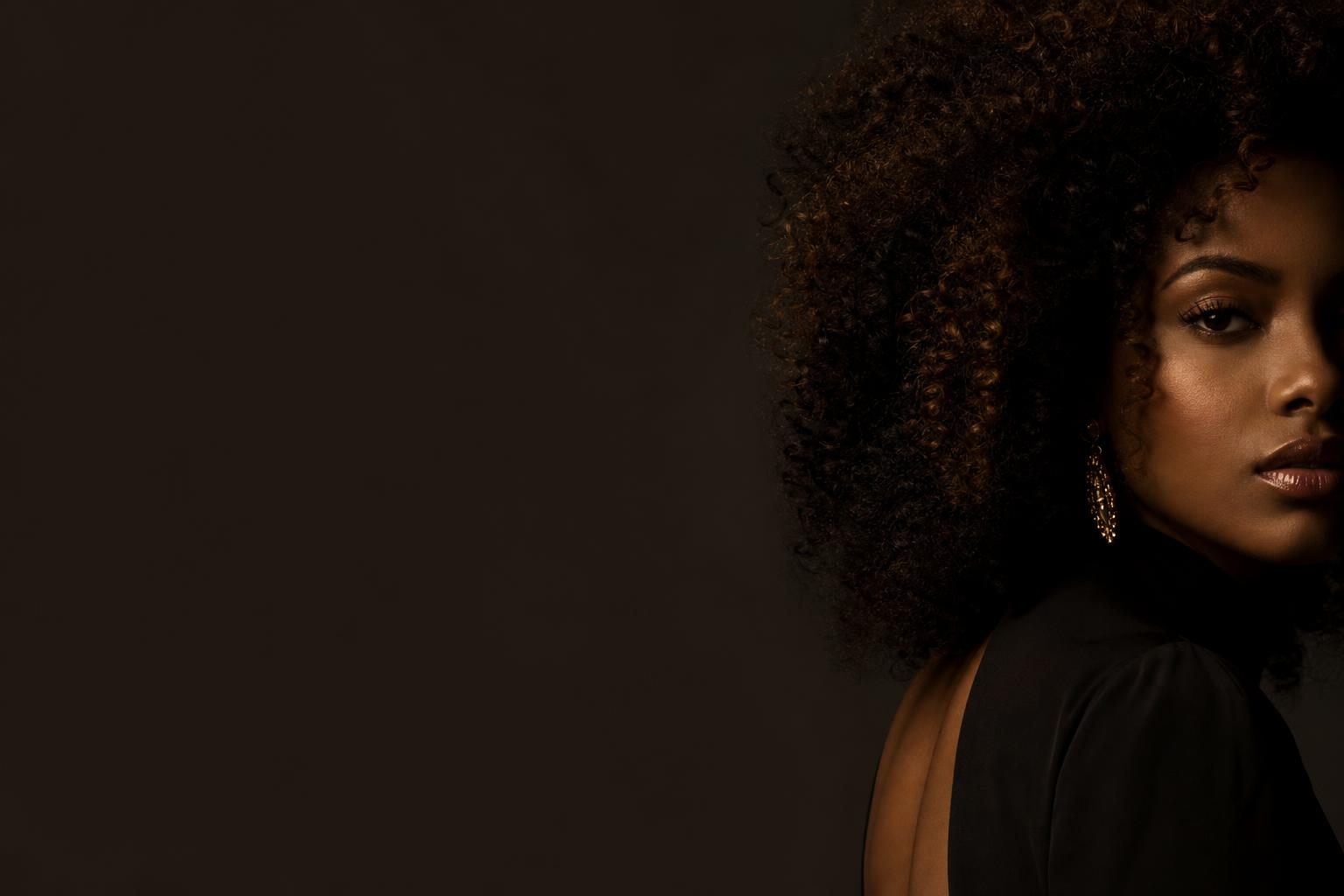 Bright studio fashion campaign portrait of a model with curly hair